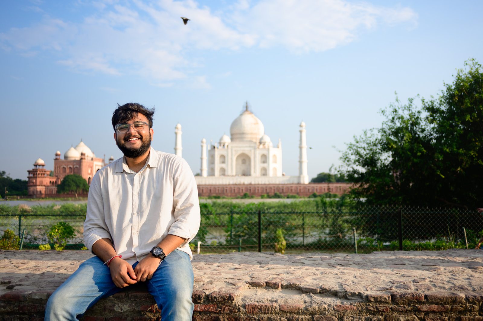 Sitting on a wall in front of the Taj Mahal at Agra